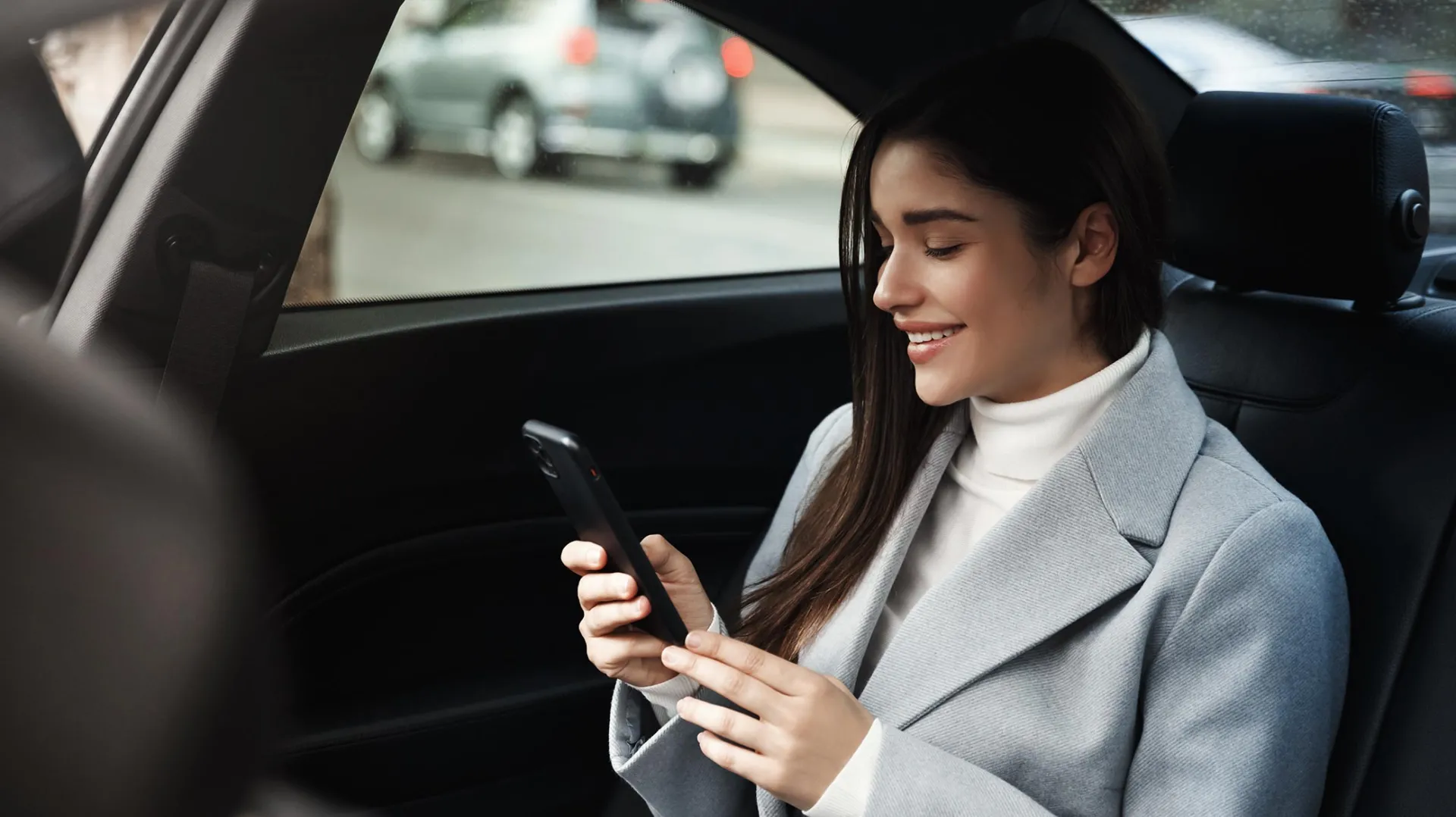 Young business woman using mobile in taxi