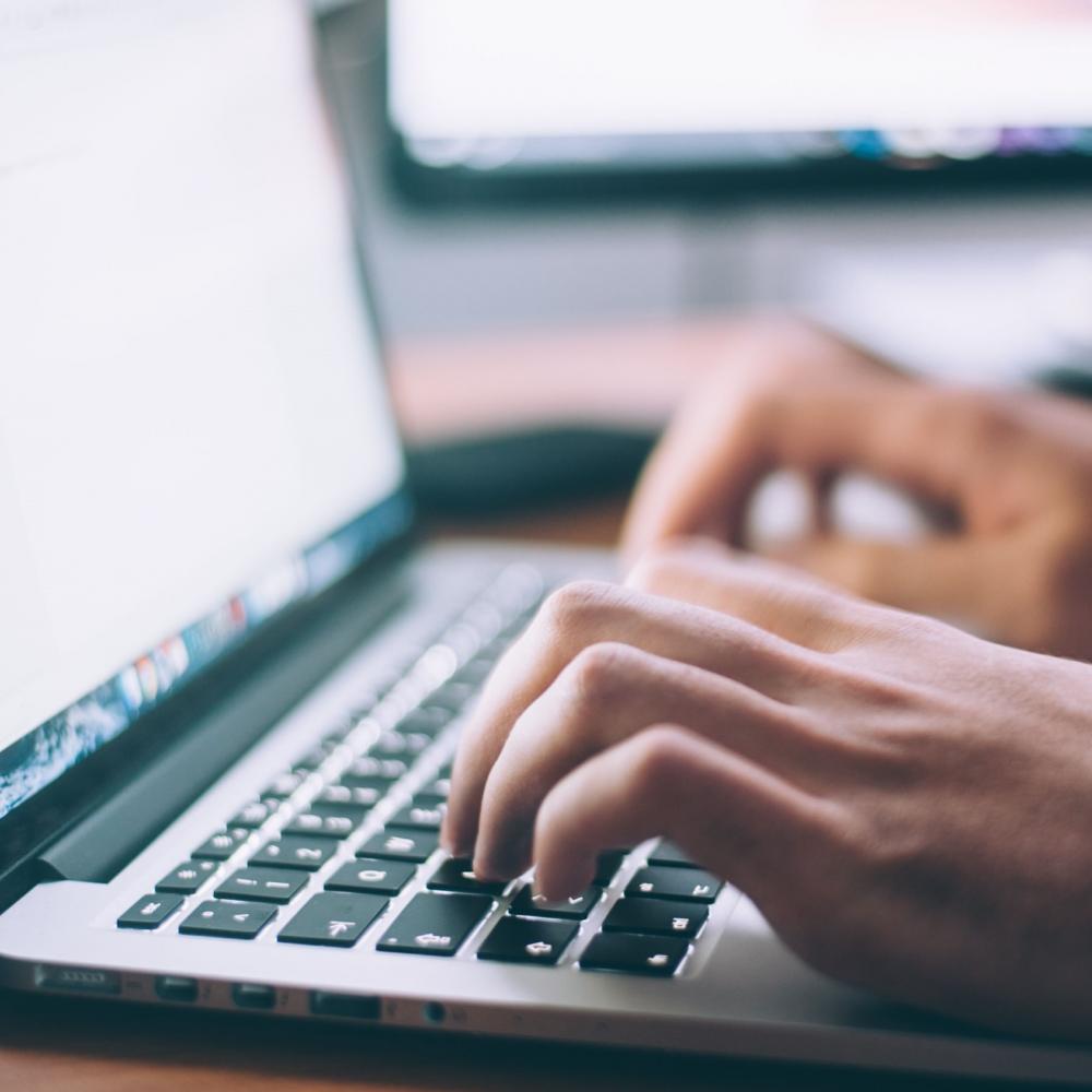 hands typing on a laptop keyboard