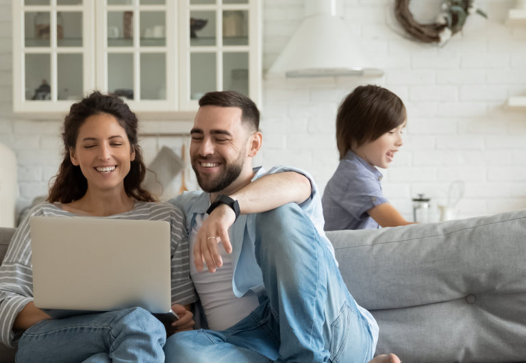 forældre der shopper online med et barn i baggrunden